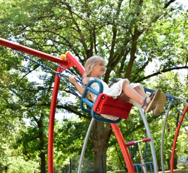 küçük bir sarışın kız bir salıncak sürme,