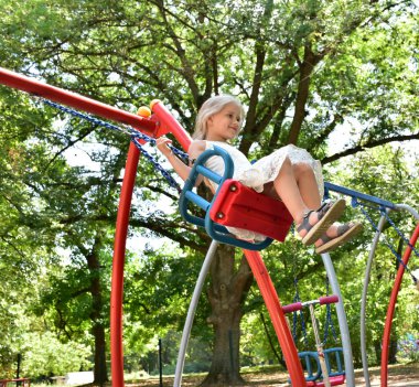 küçük bir sarışın kız bir salıncak sürme,