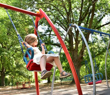 küçük bir sarışın kız bir salıncak sürme,