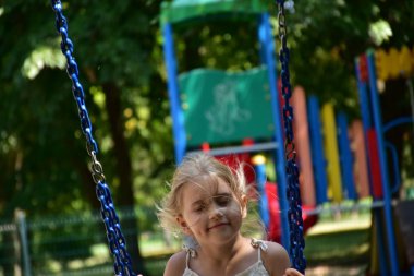 küçük bir sarışın kız bir salıncak sürme,