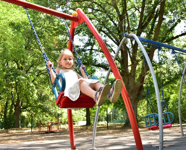 küçük bir sarışın kız bir salıncak sürme,