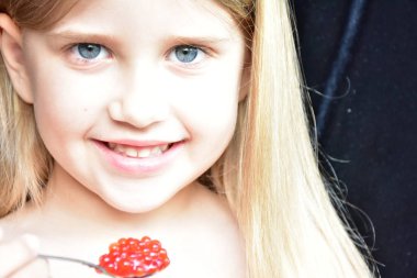 Çocuk balıktan kırmızı havyar yiyor.,