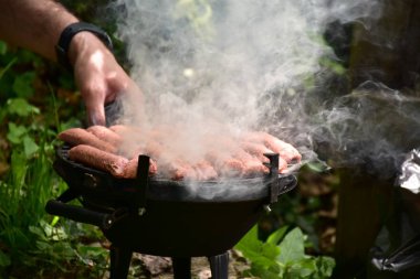 Barbeküde ızgara sosis.