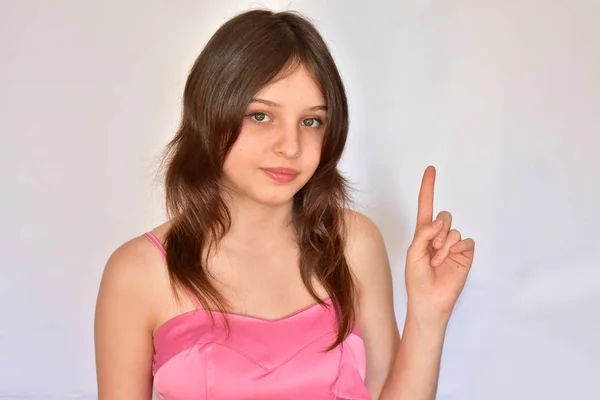 Una Ragazza Abito Rosa Mostra Gesto Uno Sfondo Bianco — Foto Stock