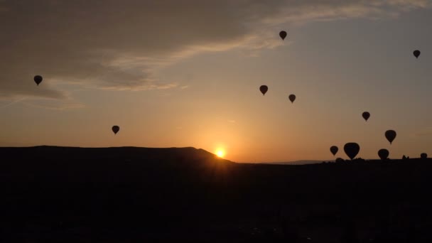 Veel van de silhouetten van hete lucht ballonnen vliegen over valleien in Goreme, Turkije. Toeristen van over de hele wereld komen naar Cappadocië te maken van een reis in een hete-lucht ballonnen. — Stockvideo