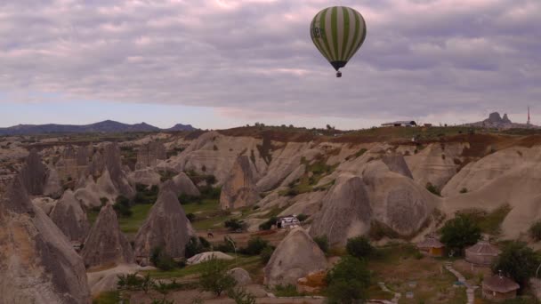 Turcja, Gogeme - 20 maja. Ogromny balon latające nad skały Cappadocia w pochmurne niebo. — Wideo stockowe