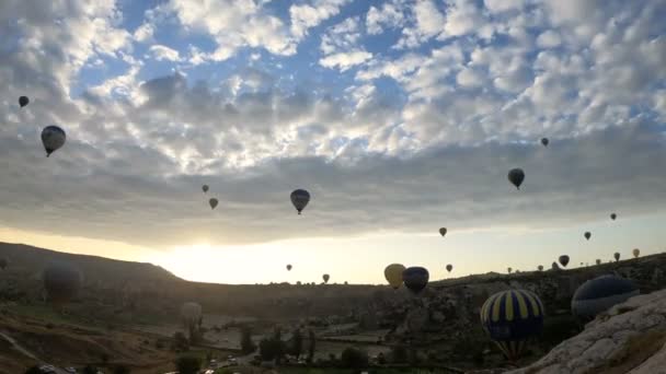 Silhouettes Beaucoup de montgolfières survolant les vallées de Goreme, en Turquie. Timelapse avec de petits nuages sur le ciel, lentille Fisheye . — Video