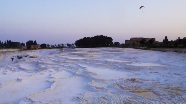 Homem em Paraplane está voando sobre Pamukkale, local natural na província de Denizli, no sudoeste da Turquia . — Vídeo de Stock