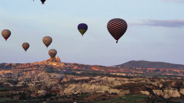 Veel van hete lucht ballonnen vliegen over valleien in Goreme, Turkije. Toeristen van over de hele wereld komen naar Cappadocië te maken van een reis in een hete-lucht ballonnen. — Stockvideo