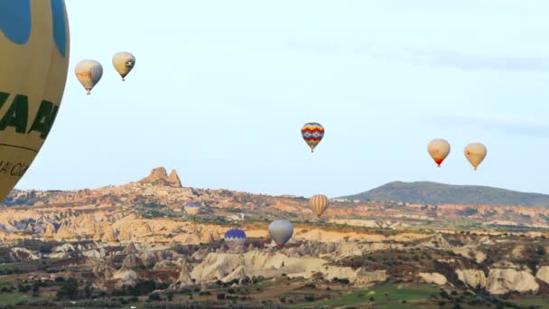 Veel van hete lucht ballonnen vliegen over valleien in Goreme, Turkije. Toeristen van over de hele wereld komen naar Cappadocië te maken van een reis in een hete-lucht ballonnen. — Stockvideo