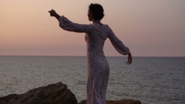 Işık elbise dans gündoğumu zaman Deniz Cliff, sevimli beyaz esmer kız