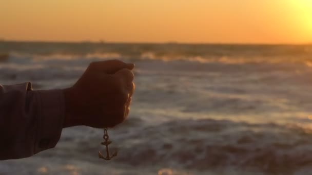 선원 남자의 손 드랍 스는 앵커 체인에 배경에서 검은 바다 위에 아름 다운 일몰 — 비디오