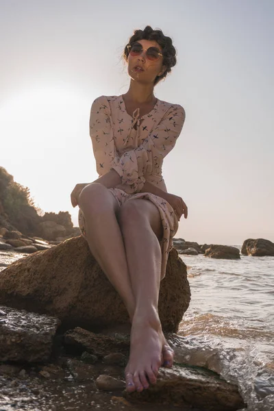 Очаровательная кавказская брюнетка в светлом платье, наслаждающаяся морем на восходе солнца . — стоковое фото