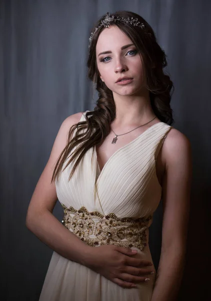 Retrato de verano de la joven hermosa dama con vestido de noche largo y blanco posando en el estudio . Fotos de stock