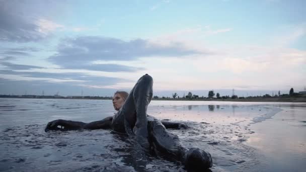 Adorável Slender loira coloca manchado em uma lama preta se parece com petróleo — Vídeo de Stock