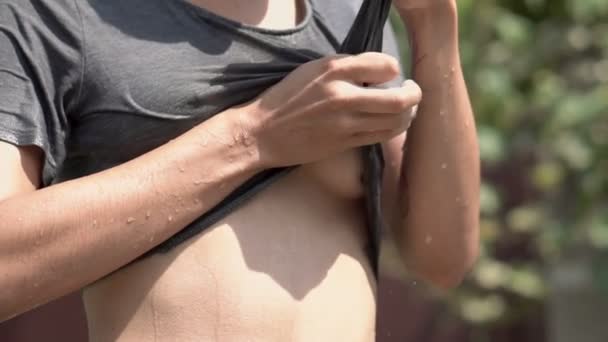 Young doorboord vrij meisje in zonnebril met plezier met de Spray van Water uit de slang in de tuin. Zomer Leisure en nat t-Shirt. Mooi lichaam — Stockvideo