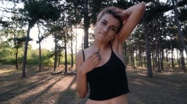 Genç oldukça Punk kız yaka ve siyah kumaş pembe saçlı günbatımı zaman çam ormanda yürüyüş