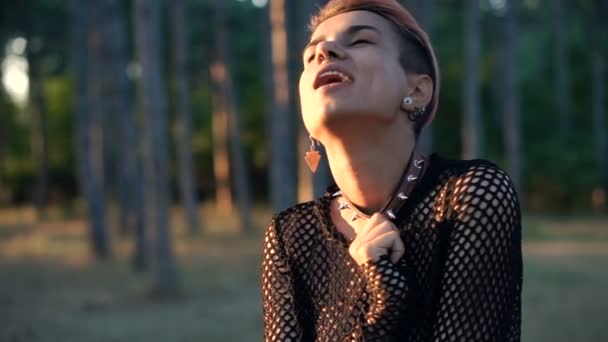 Joven chica Punk bonita en el cuello y Negro Red en el cuerpo desnudo. Chica de pelo rosa en el bosque de pinos al atardecer — Vídeo de stock