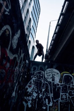 Kentsel sokak punk kız. Kız kalın köprünün altında graffiti ile boyalı duvar