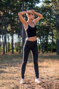 Genç oldukça Punk kız çam ormanı içinde pembe saçlı siyah top günbatımı zaman Joying yerleştirmek