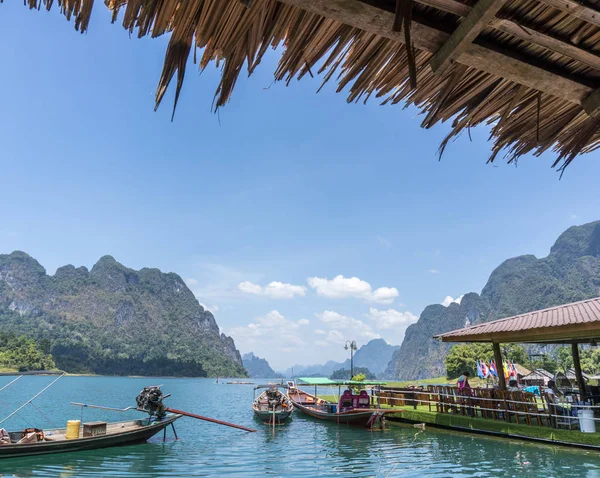 Wooden Thai traditional long-tail boat on a lake with mountains and rain forest in the background during a sunny day at Ratchaprapha Dam at Khao Sok National Park, Thailand — Stock Photo, Image