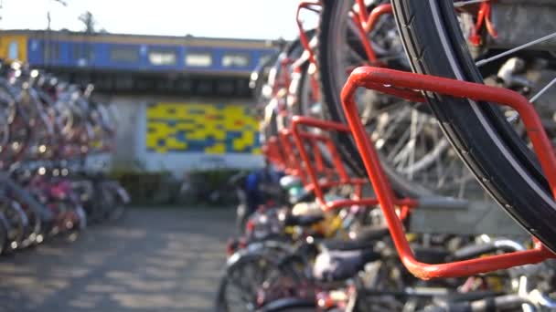 Nederlandse vrouw vergrendeling haar fiets op Parking voor fietsen in twee niveaus op Eindhoven Centraal treinstation. Europa, Nederland — Stockvideo