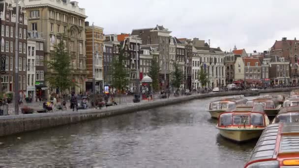 AMSTERDAM, PAÍSES BAJOS - 23 AGO 2018: timelapse video trafic on central street and water channel in Amsterdam city. Destino de viaje popular. Clima nublado . — Vídeo de stock