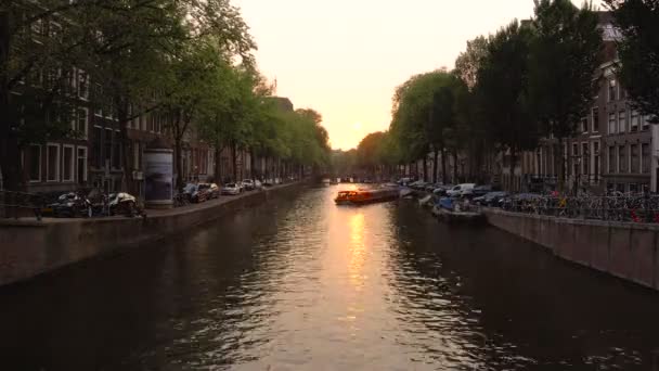 Enorma vatten båttrafiken på vatten chanel i Amsterdam city vid solnedgång. Ett populärt resmål. Molnigt väder. Timelapse video — Stockvideo