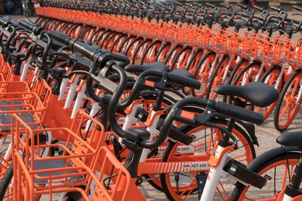 Satır genel kullanım için turuncu bisiklet sokakta park edilmiş.