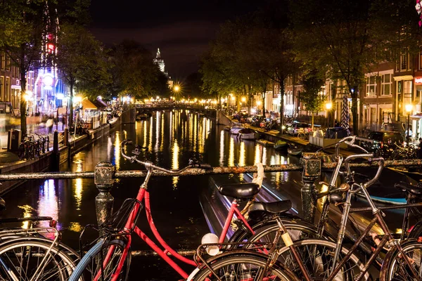 NETHERLANDS, AMSTERDAM - 23 AUG 2018: Night city view of bicycle on Amsterdam bridge and typical dutch houses, Holland, Netherlands. — Stock Photo, Image