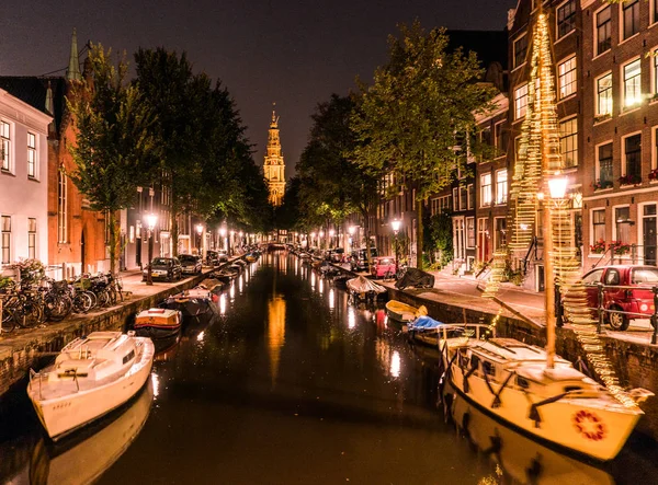 Natt över Amsterdam i staden. Båtar i en kanal och typiska holländska hus, Holland, Nederländerna. — Stockfoto