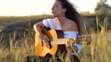 Gitar çalmak ve Körfez yamacında alanındaki şarkı kıvırcık Gipsy esmer kız