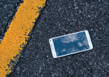 Asfalt üzerinde kırık ekran ile telefon. Birisi düştü aygıt.
