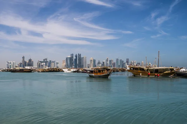 DOHA, QATAR - Feb 2018: Beautiful Doha Skyline View with Traditional Wooden Boats with Floating Qatar Flags. Corniche Broadway. Qatar, Middle East — Stock Photo, Image