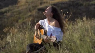 Gitar çalmak ve Körfez yamacında alanındaki şarkı kıvırcık Gipsy esmer kız