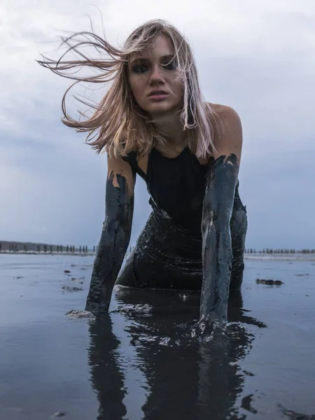 stock image Portrait of Blonde Caucasian Girl Crawls Smeared in a Healthy Black Mud in old Firth