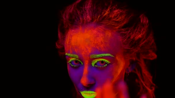 A beautiful young sexy half-naked girl dancing with glowing paint on her body in black light. Pretty woman with glowing bodyart in black lamp light. — Stock Video
