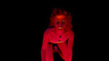 Dört ayak üzerinde vücut kışkırtıcı seyir siyah ışıkta parlayan boya ile diz çökmüş bir güzel genç seksi yarı çıplak ayakta. Siyah lamba ışığında parlayan bodyart güzel kadınla.