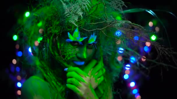 Tímido Mystic dryad verde en UV fluor luz negra con árboles brillantes en el fondo — Vídeos de Stock