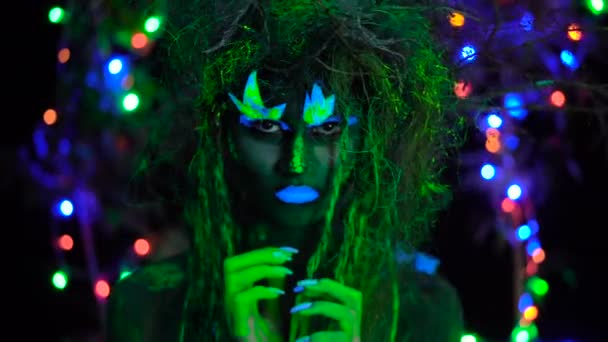 Boos angstig Mystic groene dryad in UV-fluor zwart licht met schitterende bomen op de achtergrond — Stockvideo