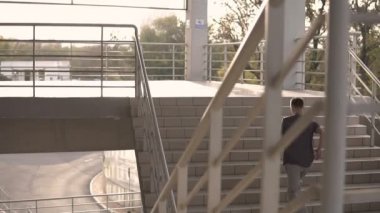 Sonbahar akşam futbol stadyumu merdivenle çalışan genç holigan streetstyle adam