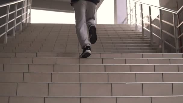 Young hooligan streetstyle guy running up by stairs on the football stadium at the evening at autumn — Stock Video