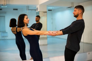Genç atletik çift çifti yoga Studio aynalar ile uygulamak koyu takım elbiseli. Çiftinde Dengeleme