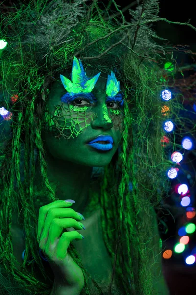 Mystic grön dryad i UV-fluor svart ljus med glödande träd på bakgrunden — Stockfoto