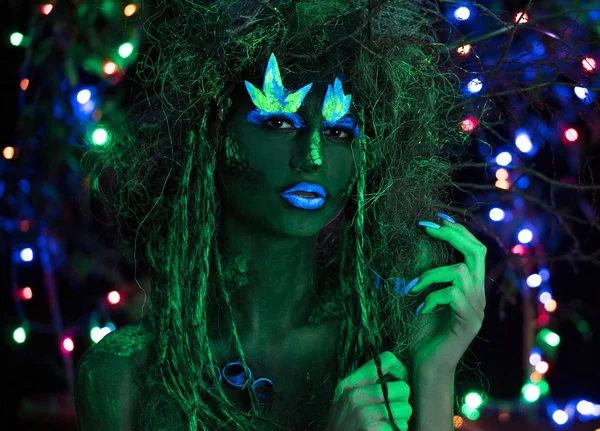 Dryad verde místico em luz UV fluor preto com árvores brilhantes no fundo — Fotografia de Stock