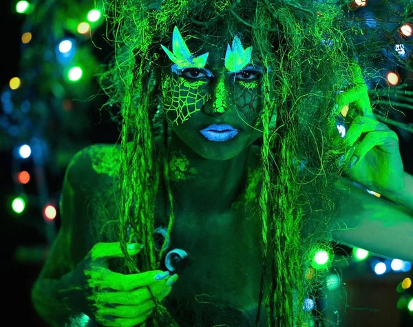 Mystic grön dryad i UV-fluor svart ljus med glödande träd på bakgrunden — Stockfoto