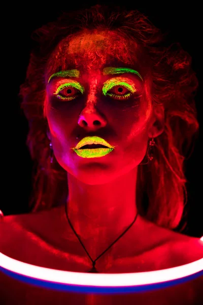 Portret van een mooie jonge sexy meisje in neon uitgeleend met ultraviolette verf op haar lichaam. Mooie vrouw met gloeiende bodyart in zwarte lamp licht — Stockfoto