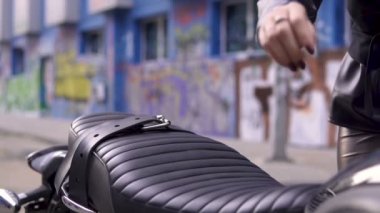 Şehir içinde siyah bir motosiklet üzerinde oturan güzel beyaz kız. Genç seksi punk kadın moda deri kentsel grafiti sahnesinde