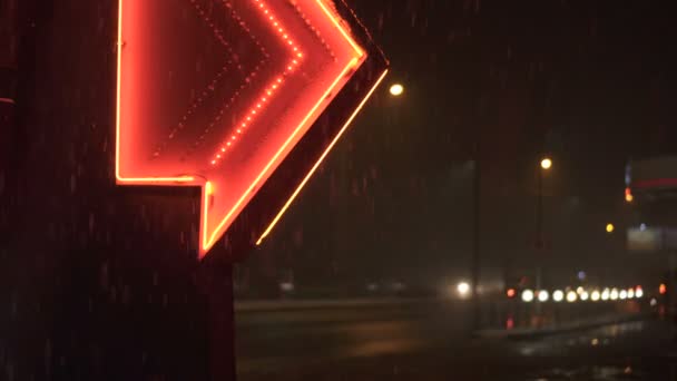 雪花在夜间落在红色的霓虹灯中 发光的箭通往加油站 背景是一条路 Uhd — 图库视频影像