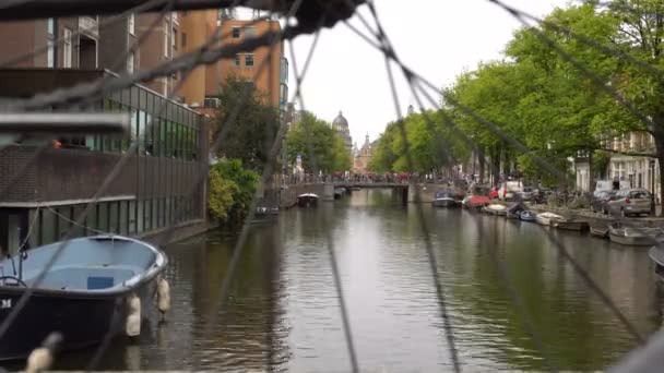 AMSTERDAM, PAYS-BAS - 23 AOÛT 2018 : trafic vidéo intemporel sur la rue centrale et le canal d'eau à Amsterdam. Destination de voyage populaire. Météo nuageuse . — Video